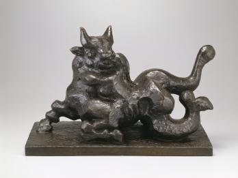 Sculpture of a bull with fish-like body carrying figure.