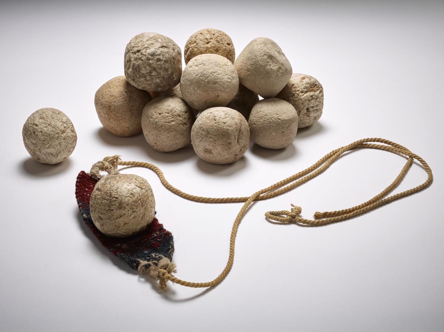 Pile of stones next to leather band attached to a cord