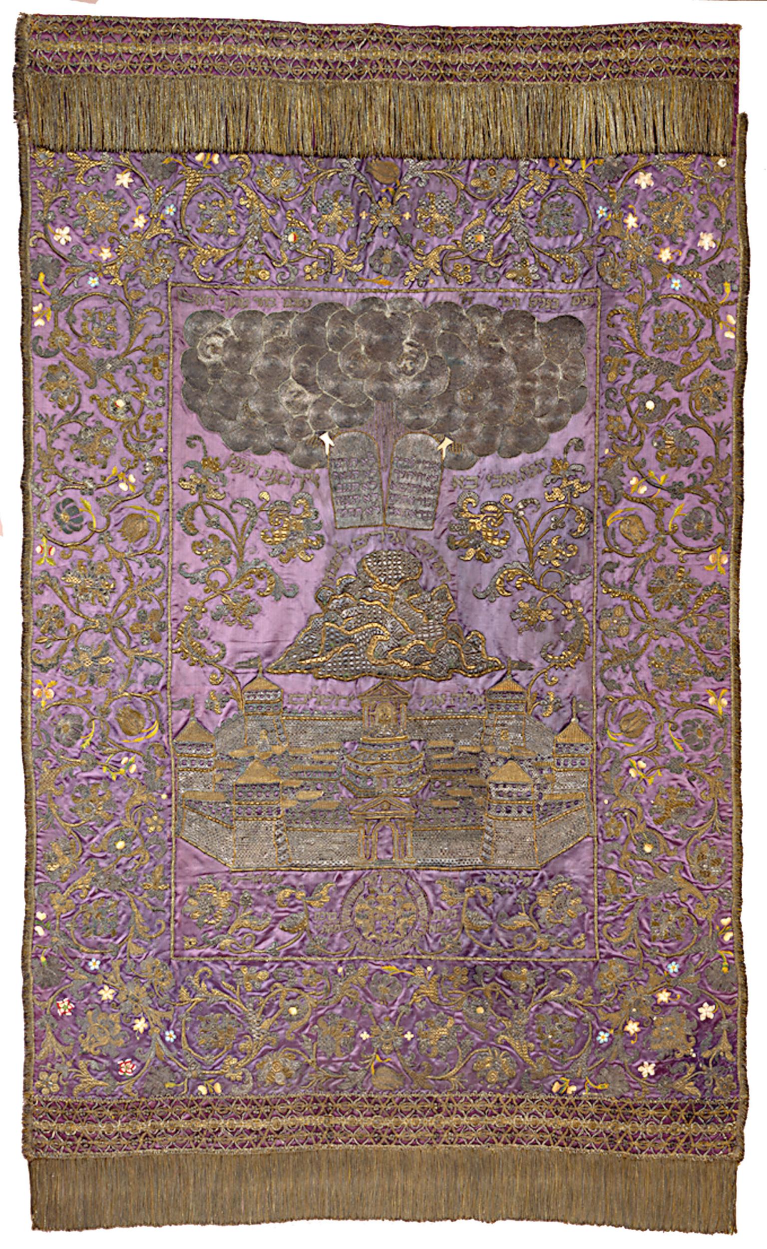 Cloth with embroidered image of tablets in clouds above mountain and city. 