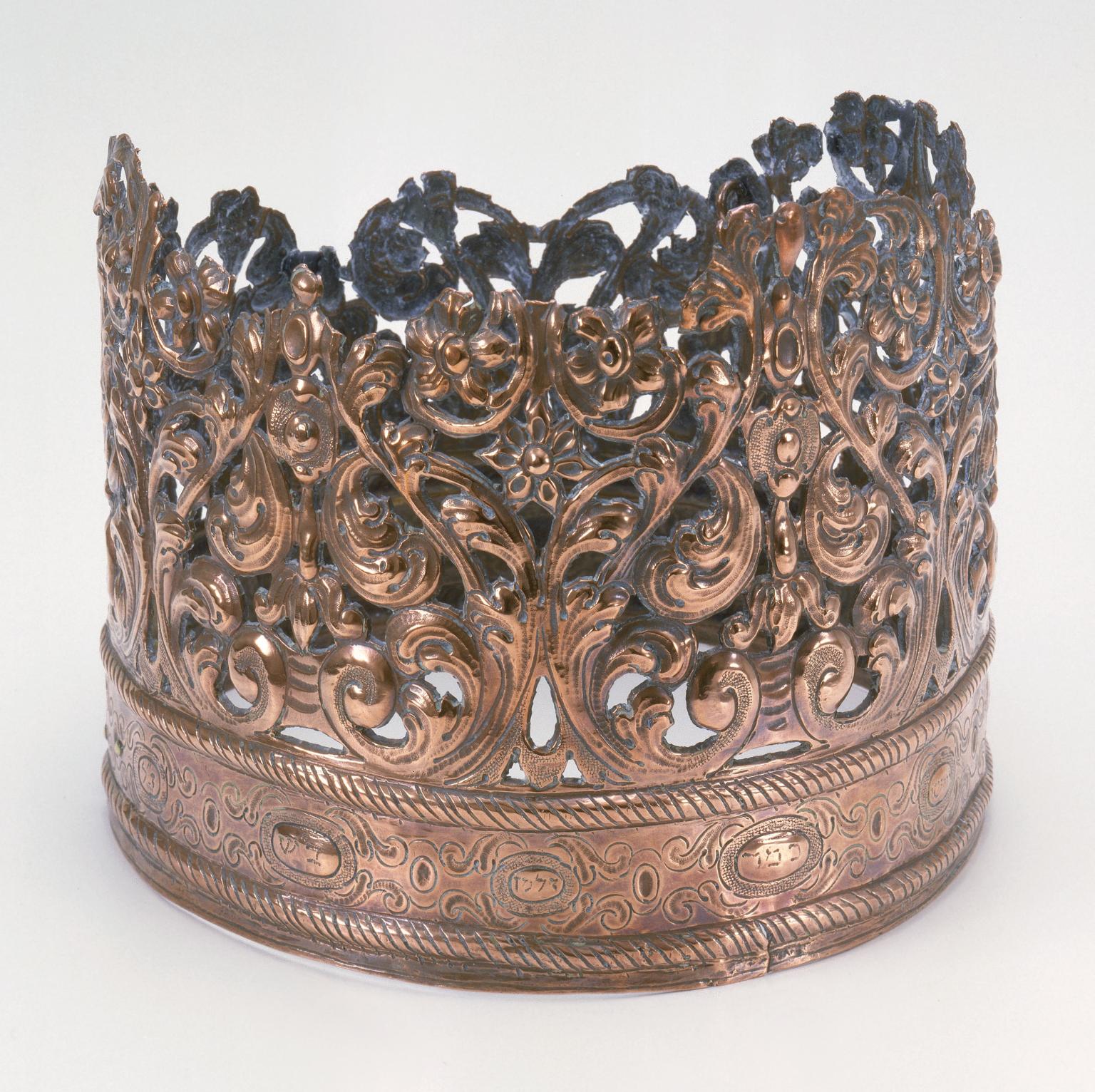 Crown with decoration above rim. 