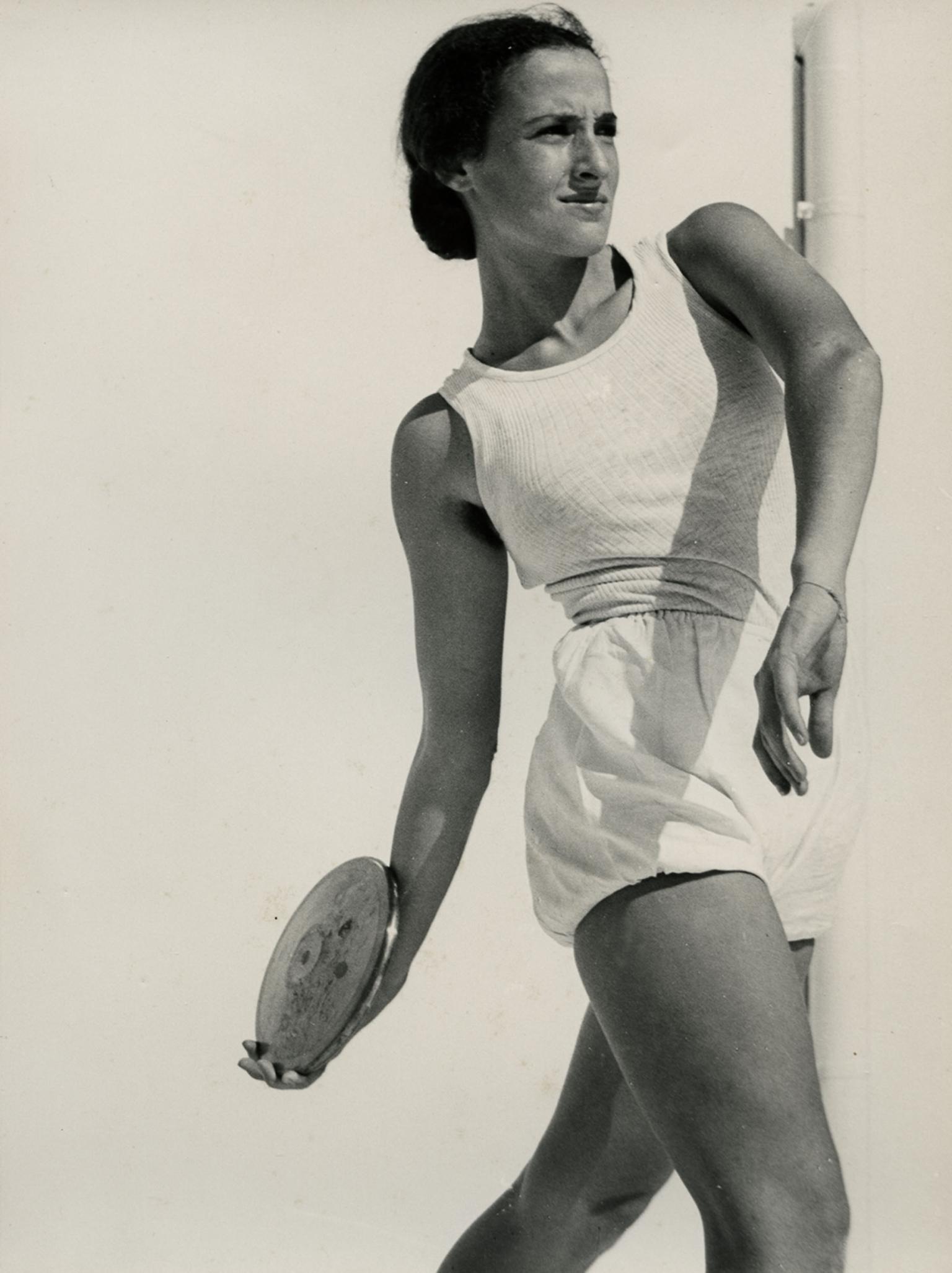 Photograph of female athlete assuming position to throw a discus.