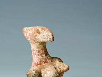 Terra-cotta figurine with enlarged head and breasts.