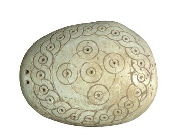Oval-shaped seashell incised with concentric circles, spirals, and dots in center of circles. 
