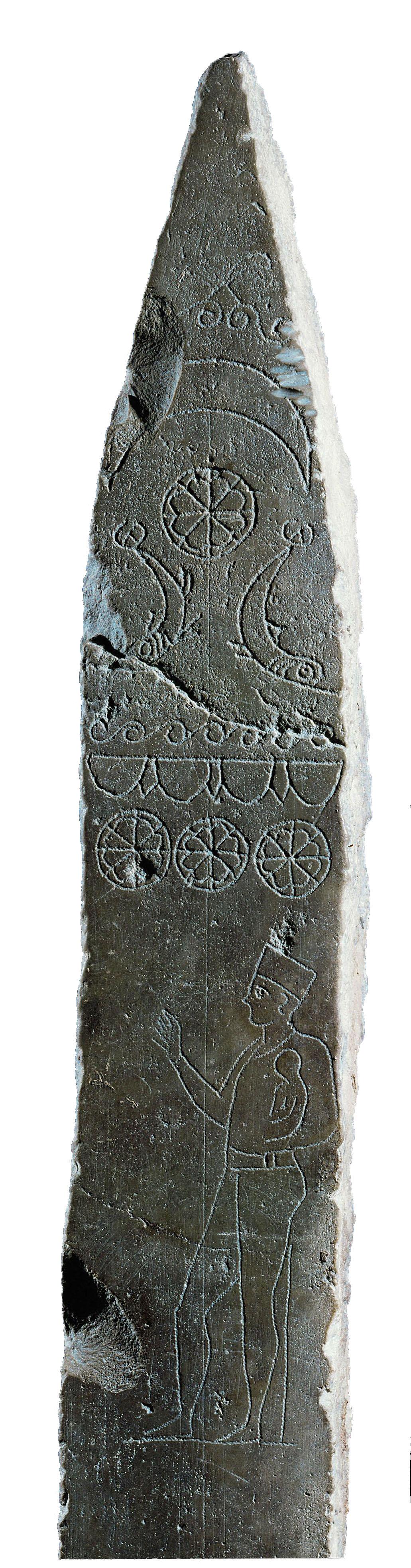 Stela with images of celestial shapes on top and man holding small child below.