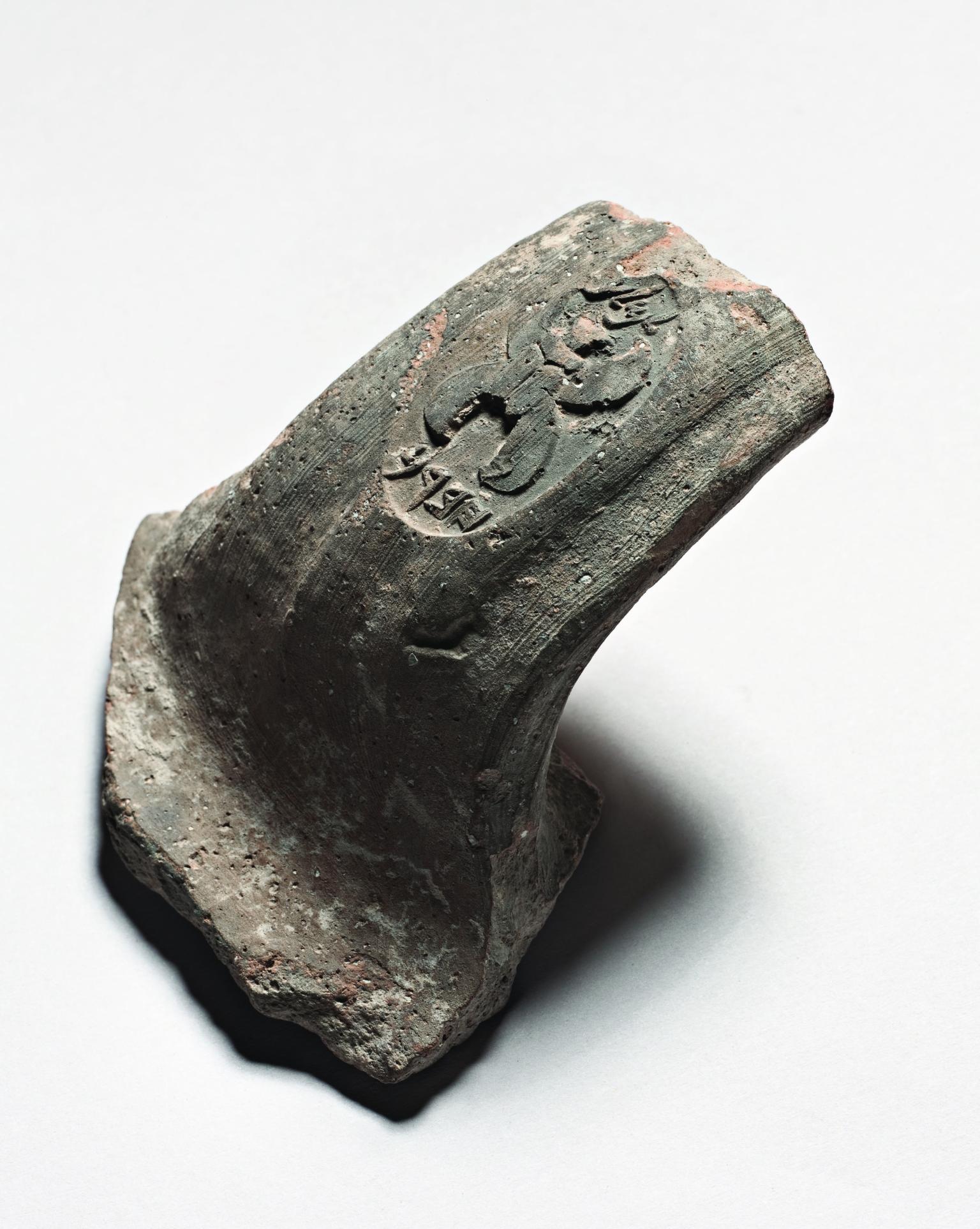 Ceramic handle with impression of large four-winged scarab beetle.