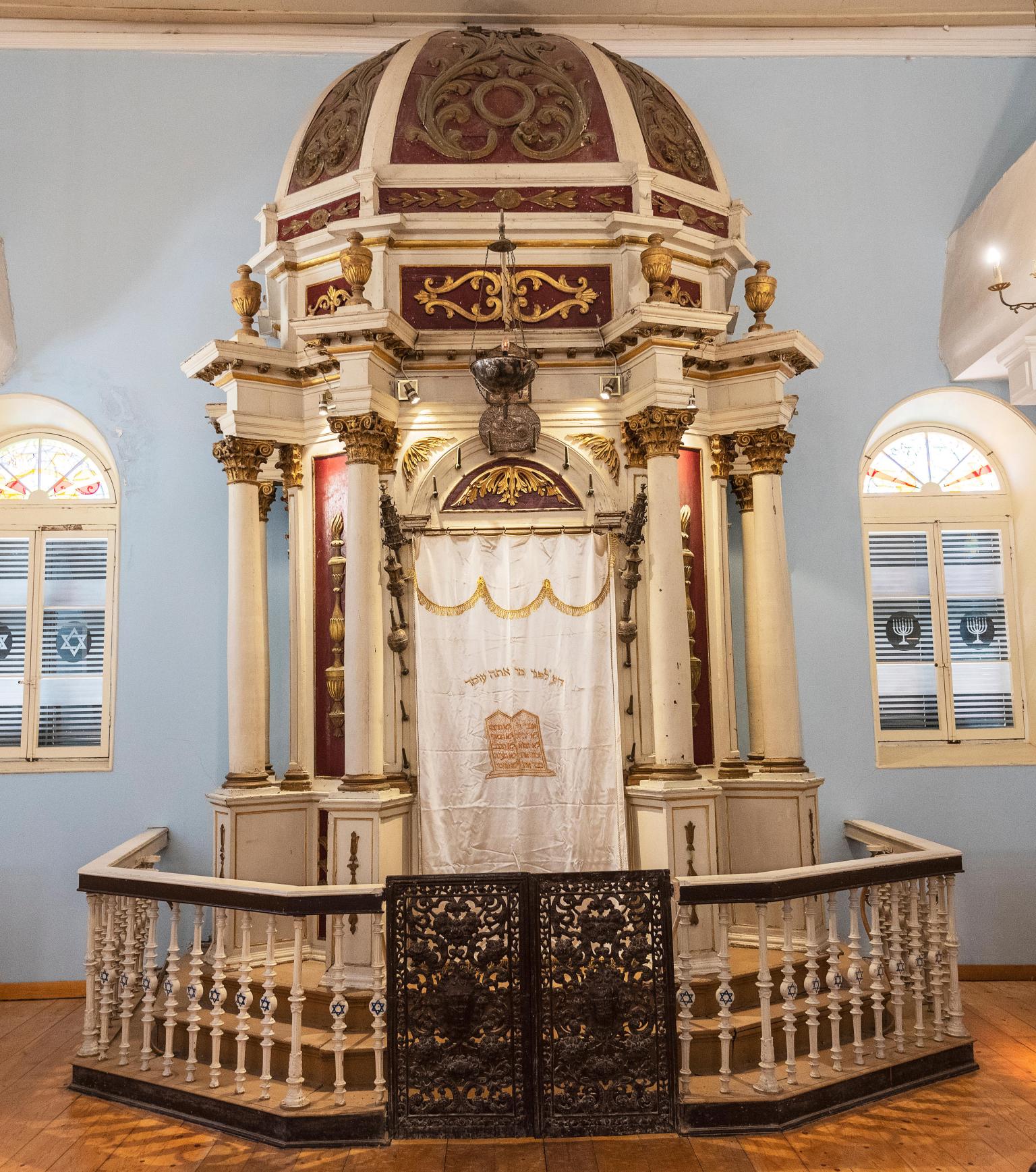 Photograph of Torah ark with domed roof surrounded by fence.