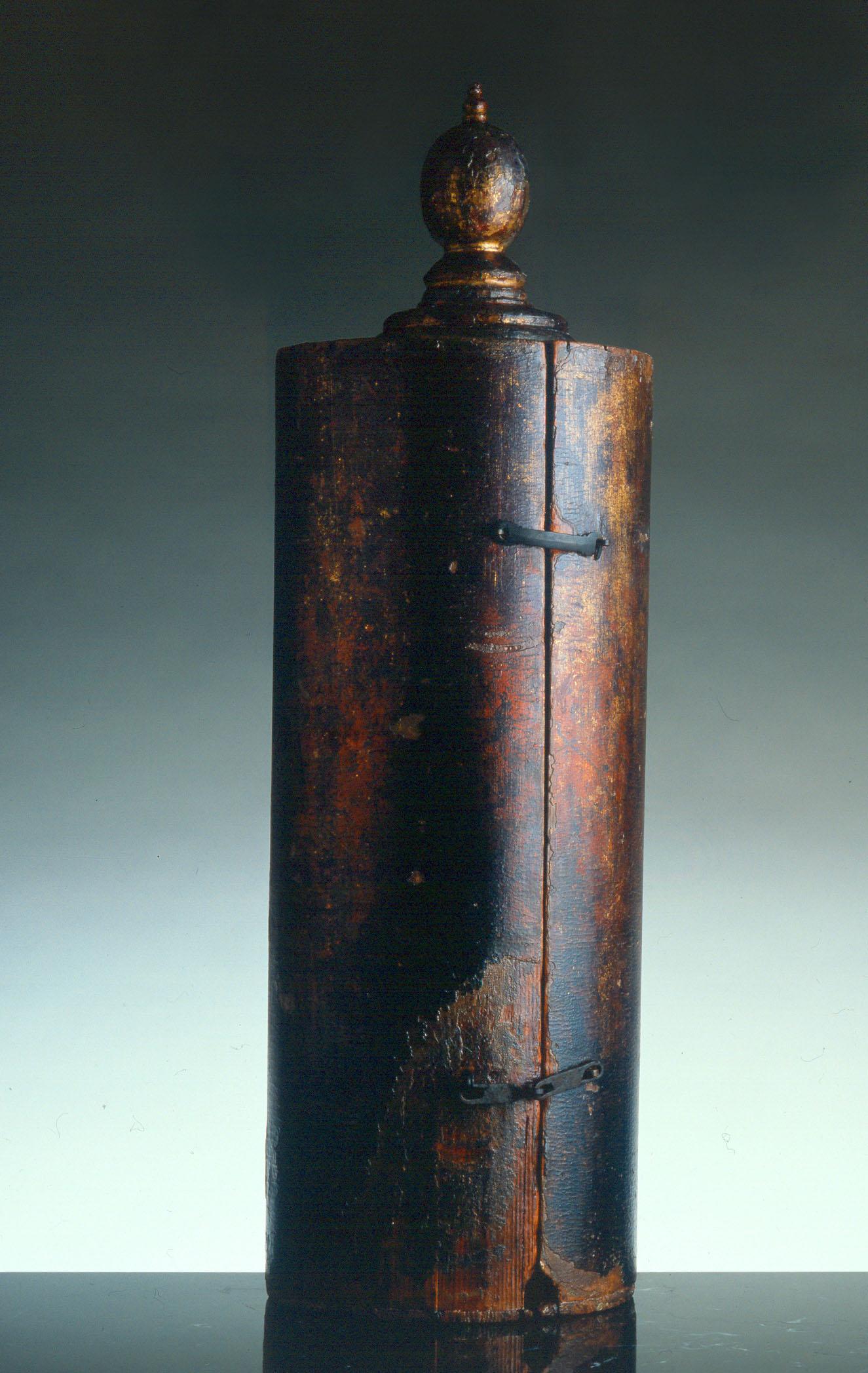 Cylindrical case with small ball on top. 