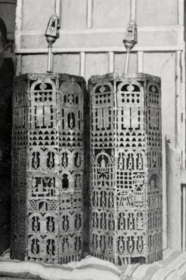 Cylindrical cases carved with geometric designs.