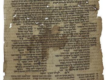 Damaged manuscript page with Hebrew script arranged variously in paragraphs and columns, mostly in black ink with some in brown, with holes obscuring some of the text.