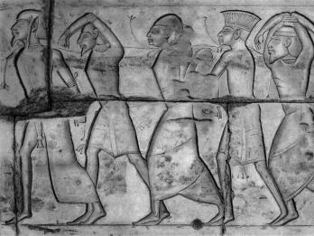 Relief of five figures in profile wearing different head coverings. 