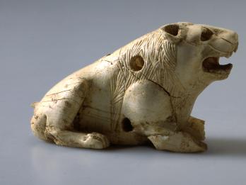 Two ivory lion figurines with open mouths and small holes throughout.