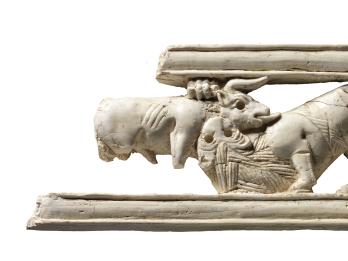 Ivory carving of a sphinx amid lotus flowers.