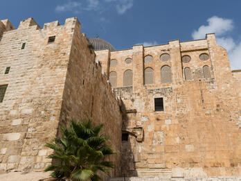 Exterior view of a historic stone building with arched windows.