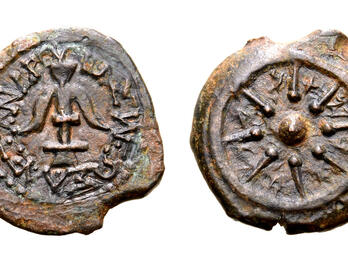 Two sides of an ancient coin: one side shows an anchor surrounded by a Greek inscription, and the other shows a small circle with eight rays radiating from it within a larger circle. Paleo-Hebrew letters are inscribed between the rays.