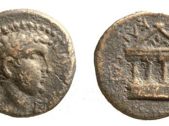 Ancient coin with a profile on one side and a depiction of a classical temple with columns on the other side; both sides show worn inscriptions.