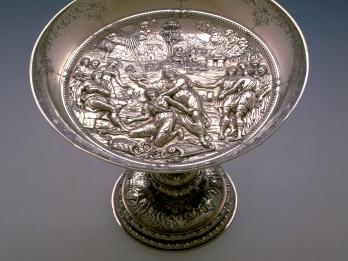 Silver dish decorated on the inside with figures and landscapes.
