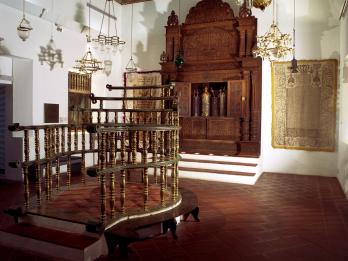 Photograph of room with raised wood platform in middle and wooden Torah ark in far wall.
