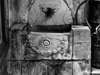 Photograph of basin with floral motif and Hebrew engraving. 