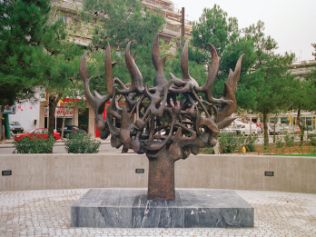 Sculpture depicting abstract tree with entangled branches in the middle of city square.