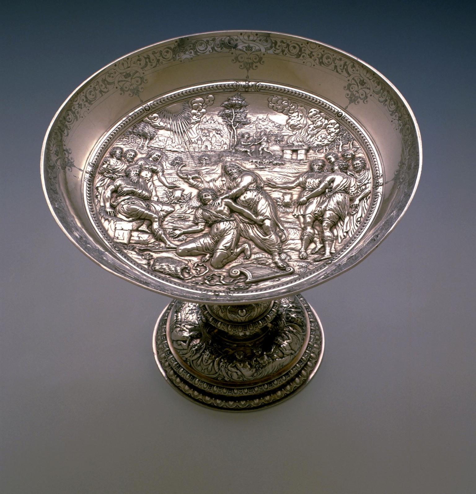 Silver dish decorated on the inside with figures and landscapes.