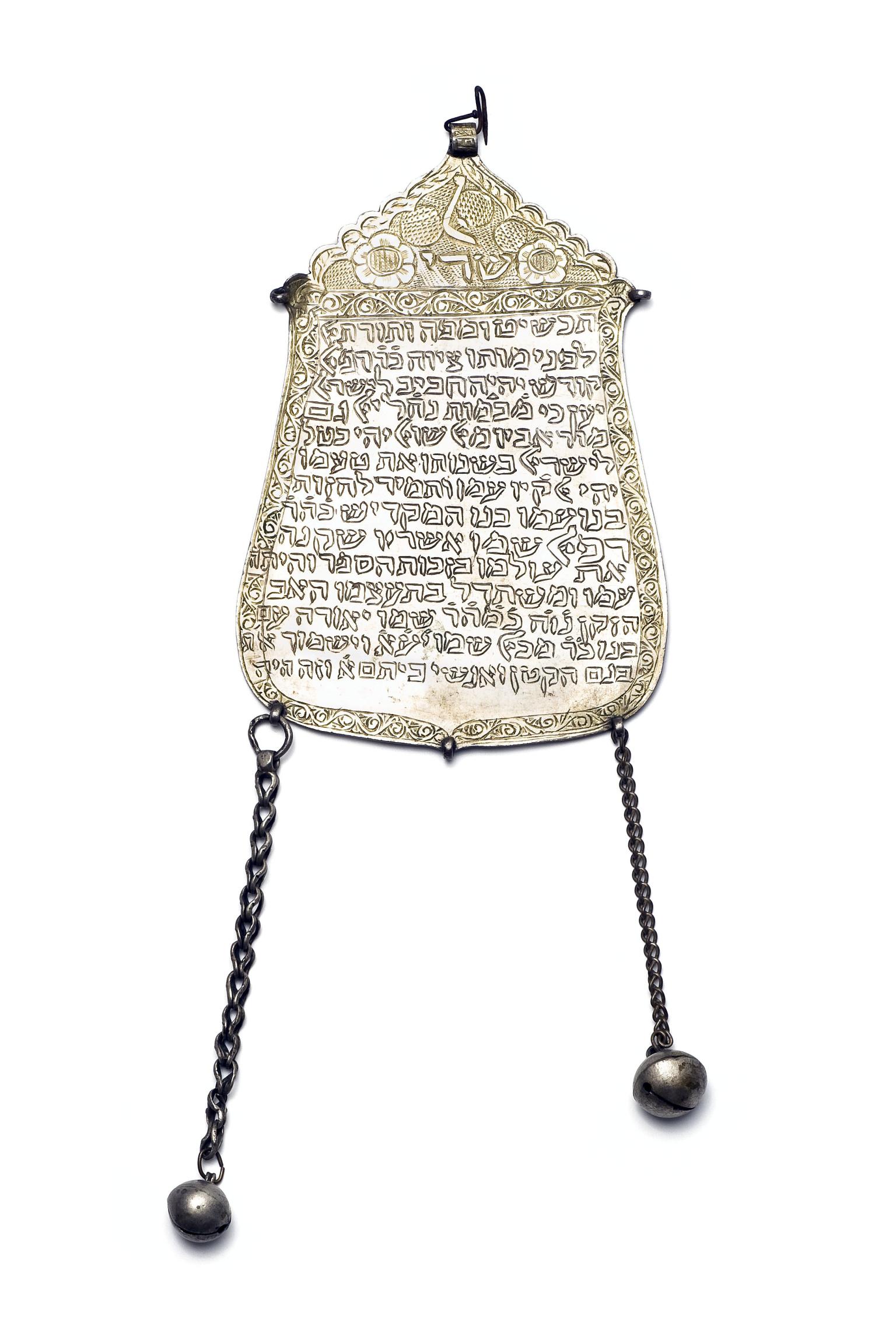 Plaque with Hebrew text and two chains hanging from the bottom.