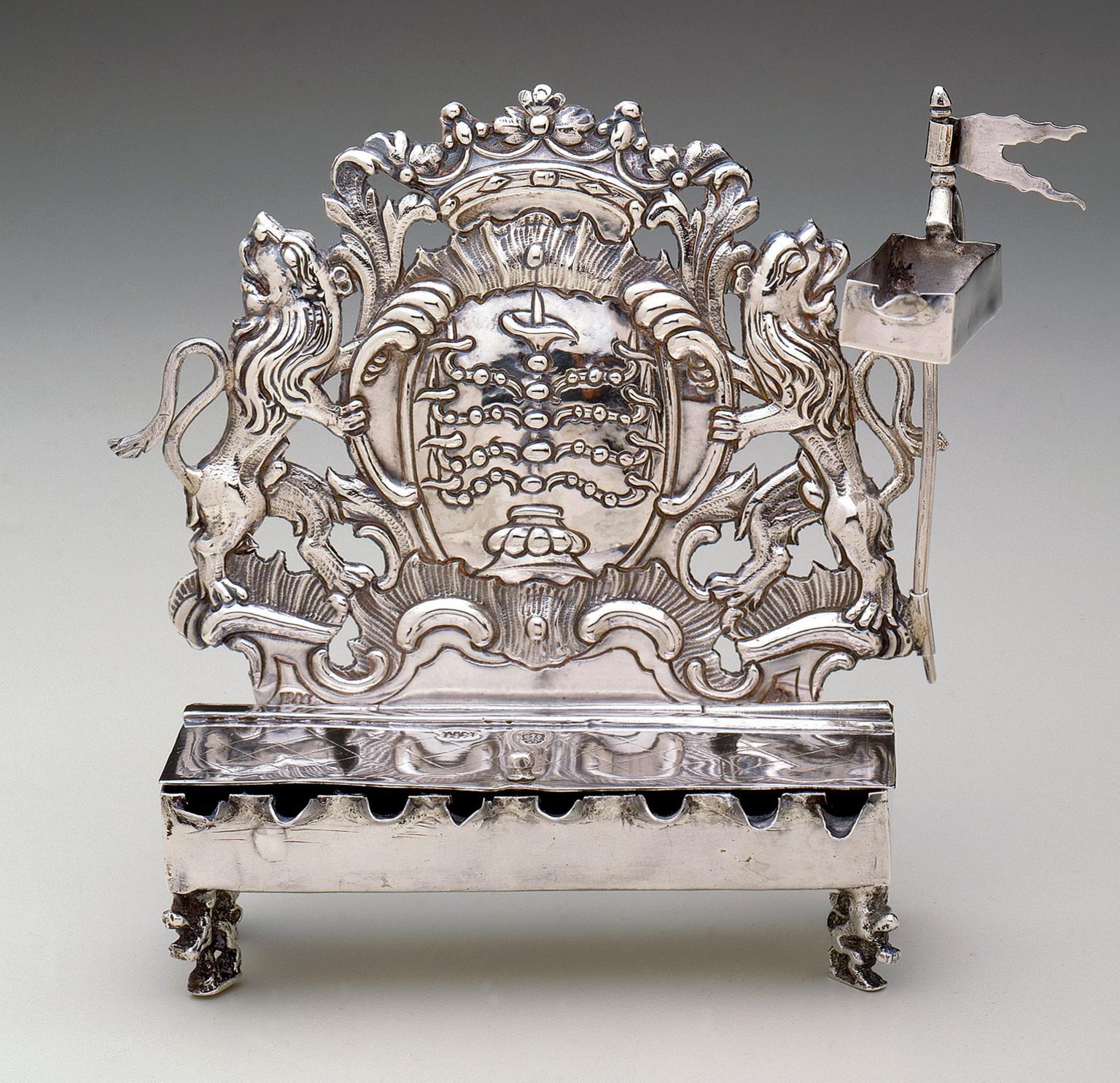 Silver oil lamp with lions on each side and crown on top. 