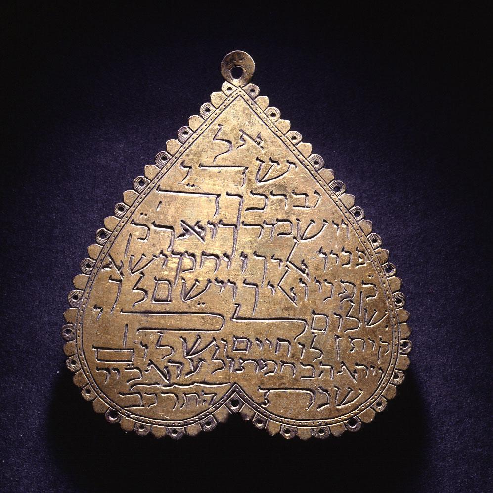 Heart-shaped amulet with Hebrew words.