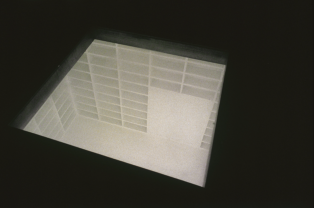 View of art installation from the top of a room with empty bookcases.