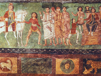 Ancient fresco showing a group of men and women in robes, some standing and gesturing, others seated on thrones. A man on horseback and a youth are on the left; decorative animal and portrait motifs run along the bottom.