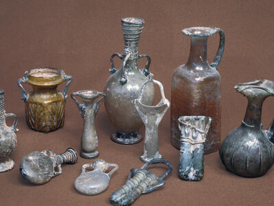 A collection of ancient glass vessels in various shapes and sizes.