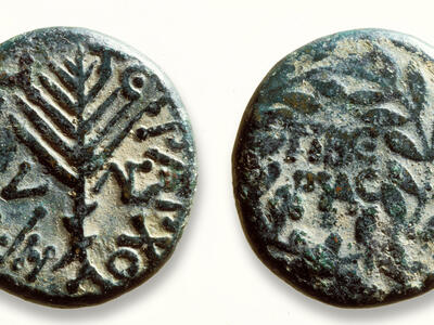 Two sides of an ancient bronze coin: one shows a stylized palm branch surrounded by Greek text, and the other has a wreath with Greek text inside.