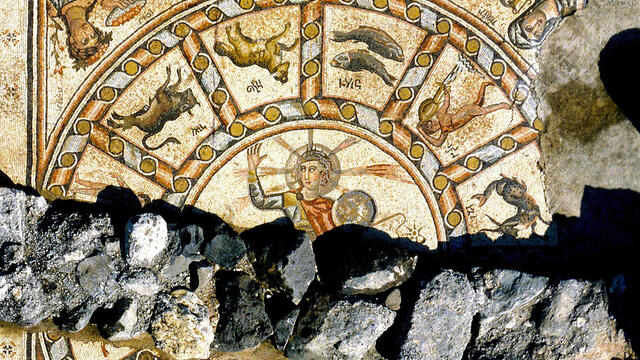 Mosaic with three registers, arranged vertically. In the center register is a depiction of a person with a halo surrounded by the zodiac. In the top register is a Torah shrine flanked by two menorahs, surrounded by ritual objects. In the bottom register is a grid with Greek inscriptions, flanked by lions.