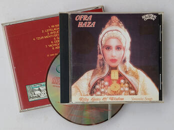Front and back of CD case with CD. The front has a picture of a woman in Yemenite dress, with the words "Ofra Haza" on the top left, and "Fifty Gates of Wisdom" and "Yemenite Songs" on the bottom.