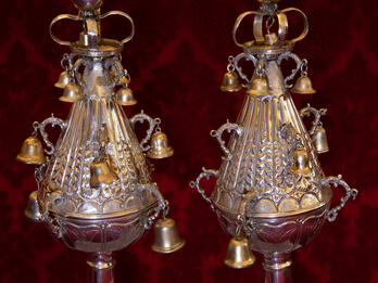 Two silver finials with bells. 