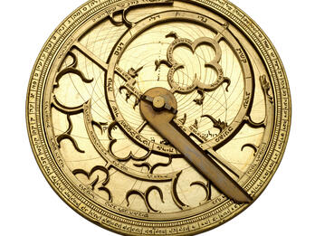 Watch-like device with concentric circles, inner geometric shapes and hands.