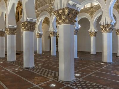 Photo of a large room with several octagonal white columns with gold decorative features.