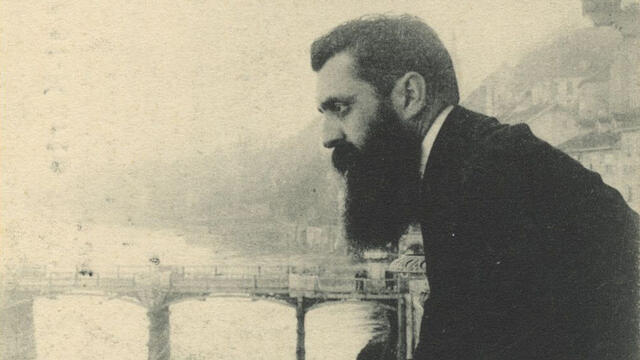 Photograph of man leaning over a bridge.