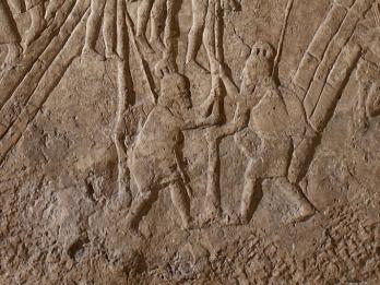 Relief of two people impaling three people. 