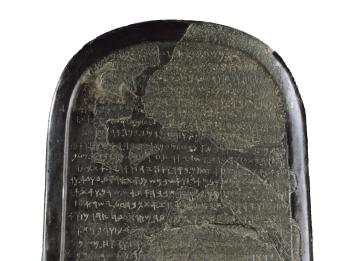 Stone with rounded top filled with Phoenician writing. 