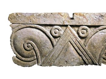 Limestone capital with triangles and carved palmette design.
