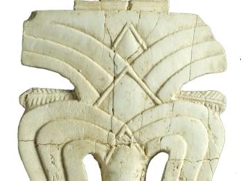 Ivory carving of date palm featuring layers of fronds with small protrusions at top and bottom.