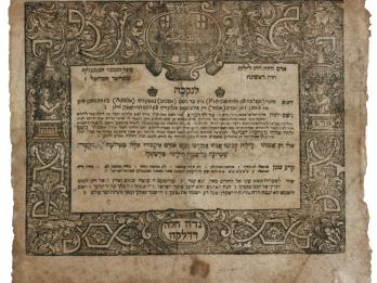 Printed page with Hebrew text in the middle surrounded by floral design and figures. 