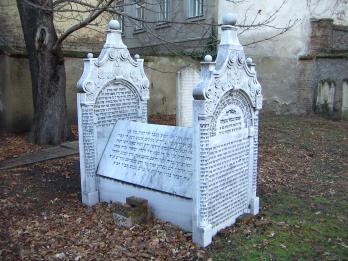 Mausoleum in graveyard of Hebrew inscription on front, back, and sides. 