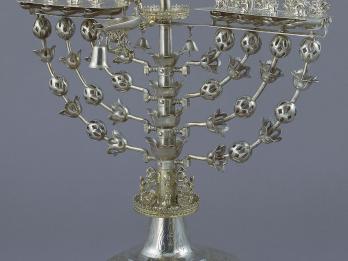 Eight-branched candelabrum with figure on top brandishing sword.