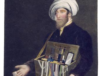 Mezzotint of peddler in turban presenting box of objects.