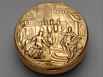 Gold circular box featuring soldiers and men with donkeys.