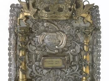 Shield with Hebrew text, gold columns, griffins, and crown on top.
