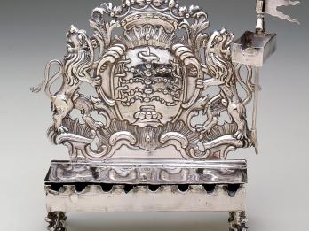Silver oil lamp with lions on each side and crown on top. 
