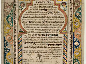 Ornamental page of Aramaic text framed by plant foliage and Stars of David at top left and right corners. 