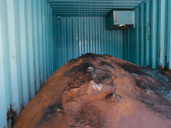 Interior of shipping container with large mound.